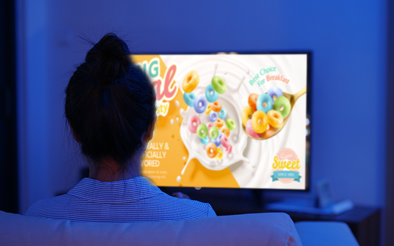 Child sits and watches while TV plays cartoons