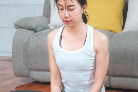 Girl does yoga pose on a yoga mat in her living room
