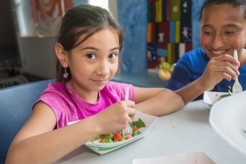 Smiling girl eats a healthy lunch